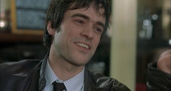 Movie still from “The Beat That My Heart Skipped” (2005), directed by Jacques Audiard – A person wearing a suit and tie; Close Up shot, Over the shoulder angle