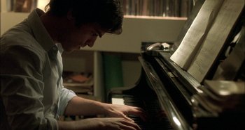 Movie still from “The Beat That My Heart Skipped” (2005), directed by Jacques Audiard – A man playing a piano in a room; Close Up shot, High angle