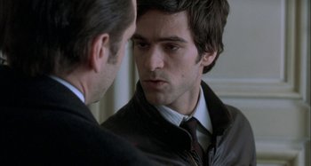Movie still from “The Beat That My Heart Skipped” (2005), directed by Jacques Audiard – A man looking at another man's reflection in a mirror; Close Up shot, Over the shoulder angle