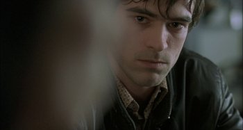 Movie still from “The Beat That My Heart Skipped” (2005), directed by Jacques Audiard – A person wearing a jacket; Close Up shot, Over the shoulder angle