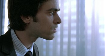 Movie still from “The Beat That My Heart Skipped” (2005), directed by Jacques Audiard – A person wearing a suit and tie; Close Up shot, Over the shoulder angle