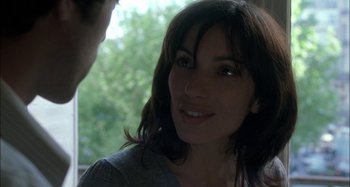 Movie still from “The Beat That My Heart Skipped” (2005), directed by Jacques Audiard – A person smiling at the camera; Close Up shot, Over the shoulder angle
