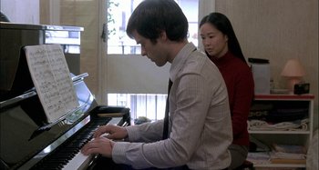 Movie still from “The Beat That My Heart Skipped” (2005), directed by Jacques Audiard – A man and a woman are playing piano together; Medium shot, Over the shoulder angle
