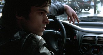 Movie still from “The Beat That My Heart Skipped” (2005), directed by Jacques Audiard – A man sitting in the drivers seat of a car; Close Up shot, High angle