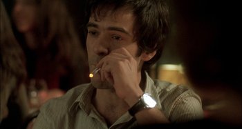 Movie still from “The Beat That My Heart Skipped” (2005), directed by Jacques Audiard – A man smoking a cigarette while sitting at a table; Close Up shot, Over the shoulder angle