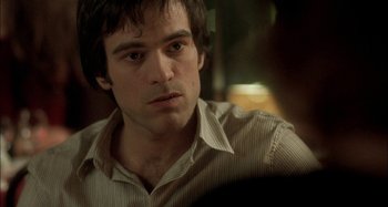 Movie still from “The Beat That My Heart Skipped” (2005), directed by Jacques Audiard – A person sitting in a room; Close Up shot, Over the shoulder angle
