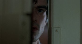 Movie still from “The Beat That My Heart Skipped” (2005), directed by Jacques Audiard – A man's face as he peeks through a door; Extreme Close Up shot, Over the shoulder angle