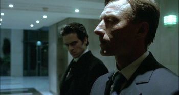 Movie still from “The Beat That My Heart Skipped” (2005), directed by Jacques Audiard – Two men in suits and ties standing next to each other; Close Up shot, Over the shoulder angle