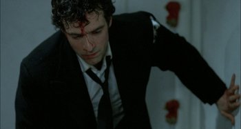 Movie still from “The Beat That My Heart Skipped” (2005), directed by Jacques Audiard – A man in a suit and tie with a bloody forehead; Close Up shot, High angle
