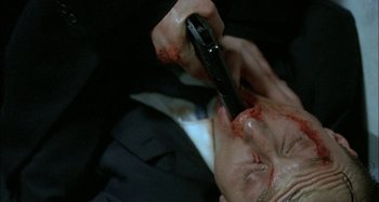Movie still from “The Beat That My Heart Skipped” (2005), directed by Jacques Audiard – A man with blood all over his face holding a cell phone; Extreme Close Up shot, Overhead angle