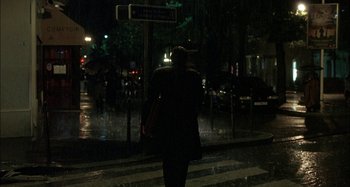 Movie still from “The Beat That My Heart Skipped” (2005), directed by Jacques Audiard – A person walking on a street at night; Extreme Wide shot, Over the shoulder angle