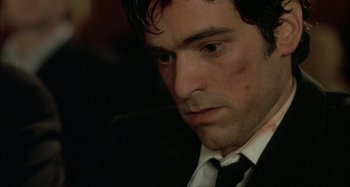 Movie still from “The Beat That My Heart Skipped” (2005), directed by Jacques Audiard – A person wearing a suit and tie; Close Up shot, High angle