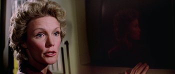 Movie still from “The Black Hole” (1979), directed by Gary Nelson – A woman's face in front of a television; Close Up shot, Low angle