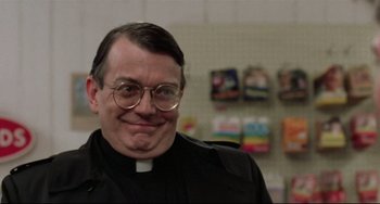 Movie still from “The Blob” (1988), directed by Chuck Russell – A man wearing glasses and a priest's outfit; Close Up shot, Low angle