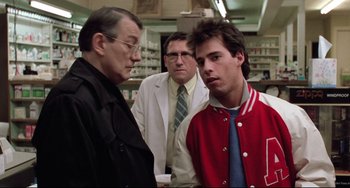 Movie still from “The Blob” (1988), directed by Chuck Russell – A group of men standing next to each other in a room; Medium shot, Over the shoulder angle