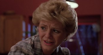 Movie still from “The Blob” (1988), directed by Chuck Russell – An older woman with a frowning look on her face; Close Up shot, Low angle