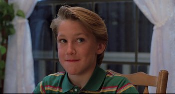 Movie still from “The Blob” (1988), directed by Chuck Russell – A young boy with blonde hair wearing a green shirt; Close Up shot, Low angle