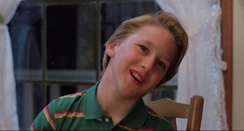 Movie still from “The Blob” (1988), directed by Chuck Russell – A young boy smiling for the camera; Close Up shot, Low angle