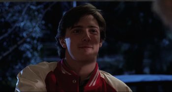 Movie still from “The Blob” (1988), directed by Chuck Russell – A young man in a red and white baseball jacket; Close Up shot, Low angle