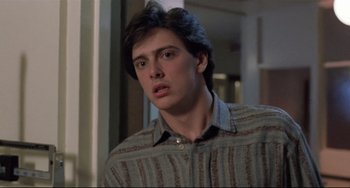 Movie still from “The Blob” (1988), directed by Chuck Russell – A young man in a striped shirt looking at the camera; Close Up shot, Low angle