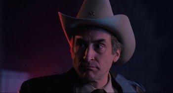 Movie still from “The Blob” (1988), directed by Chuck Russell – A man wearing a cowboy hat and a suit; Close Up shot, Low angle
