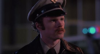 Movie still from “The Blob” (1988), directed by Chuck Russell – A man with a mustache wearing a hat and a uniform; Close Up shot, Low angle