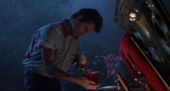 Movie still from “The Blob” (1988), directed by Chuck Russell – A young man holding a glass of juice; Medium shot, Low angle
