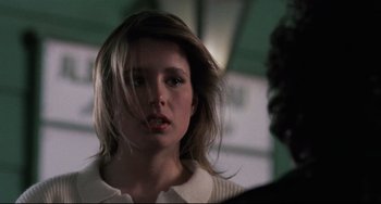 Movie still from “The Blob” (1988), directed by Chuck Russell – A woman with long blonde hair is looking at the camera; Close Up shot, Over the shoulder angle