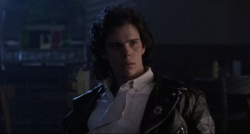 Movie still from “The Blob” (1988), directed by Chuck Russell – A man with long hair wearing a leather jacket; Close Up shot, Low angle