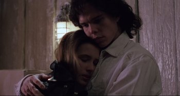 Movie still from “The Blob” (1988), directed by Chuck Russell – A man and a woman embracing each other in a dark room; Close Up shot, Low angle