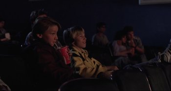 Movie still from “The Blob” (1988), directed by Chuck Russell – Two young boys are watching a movie in a theater; Medium shot, High angle