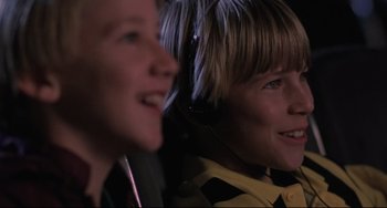 Movie still from “The Blob” (1988), directed by Chuck Russell – Two young boys wearing headphones smiling for the camera; Close Up shot, High angle