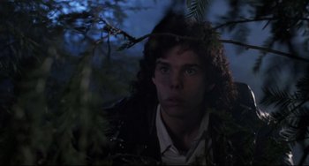 Movie still from “The Blob” (1988), directed by Chuck Russell – A man with long dark hair is looking at the camera; Close Up shot, Low angle