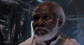 Movie still from “The Blob” (1988), directed by Chuck Russell – An older man with a beard and a white shirt; Close Up shot, Low angle