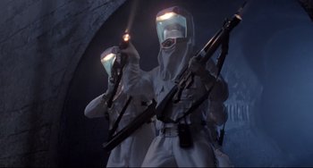 Movie still from “The Blob” (1988), directed by Chuck Russell – A couple of people that are holding guns in their hands; Medium shot, Low angle