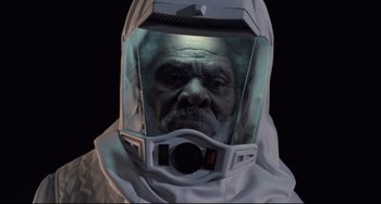 Movie still from “The Blob” (1988), directed by Chuck Russell – An old man wearing a space suit and a helmet; Close Up shot, Overhead angle