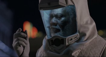 Movie still from “The Blob” (1988), directed by Chuck Russell – An african american man wearing a space suit and a helmet; Close Up shot, Low angle