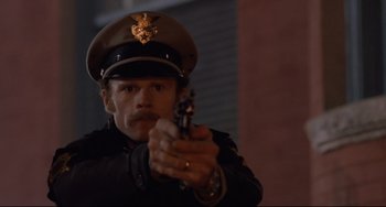 Movie still from “The Blob” (1988), directed by Chuck Russell – A man in a uniform holding a toy gun; Close Up shot, Low angle