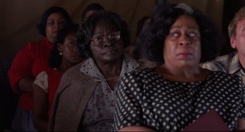 Movie still from “The Blob” (1988), directed by Chuck Russell – A group of people sitting in a room; Close Up shot, Over the shoulder angle