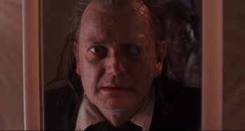 Movie still from “The Blob” (1988), directed by Chuck Russell – A person wearing a suit and tie; Close Up shot, Low angle
