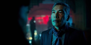 Movie still from “Altered Carbon” (2018), created by Laeta Kalogridis – A man wearing a suit and tie standing in front of neon lights; Close Up shot, Over the shoulder angle