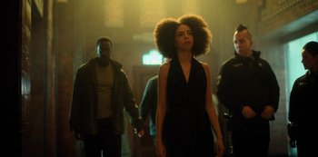 Movie still from “Altered Carbon” (2018), created by Laeta Kalogridis – A group of people walking down a street; Medium shot, Low angle