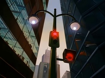 Movie still from “The Brave Little Toaster” (1987), directed by Jerry Rees – A traffic light on a pole in front of some buildings; Extreme Wide shot, Low angle