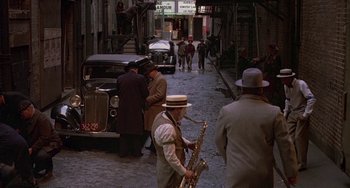 Movie still from “The Brink's Job” (1978), directed by William Friedkin – A group of people walking down a street with cars; Extreme Wide shot, High angle