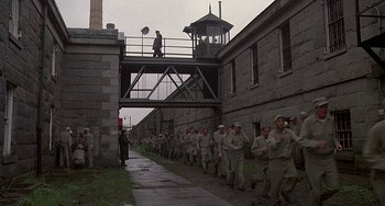 Movie still from “The Brink's Job” (1978), directed by William Friedkin – A large group of men walking down a street; Extreme Wide shot, High angle