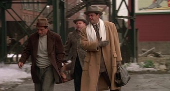 Movie still from “The Brink's Job” (1978), directed by William Friedkin – A group of men walking down a street; Medium shot, Low angle