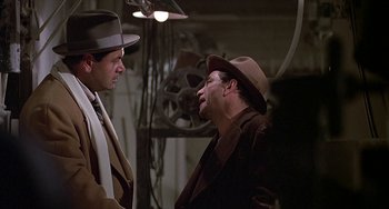 Movie still from “The Brink's Job” (1978), directed by William Friedkin – A man in a hat and a man in a suit and tie; Medium shot, Over the shoulder angle