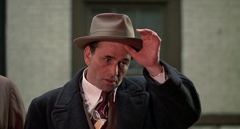 Movie still from “The Brink's Job” (1978), directed by William Friedkin – A man wearing a hat and a tie; Close Up shot, Low angle