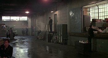 Movie still from “The Brink's Job” (1978), directed by William Friedkin – A man standing on the stairs; Wide shot, High angle