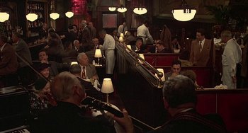 Movie still from “The Brink's Job” (1978), directed by William Friedkin – A group of people sitting at a table in a restaurant; Wide shot, High angle